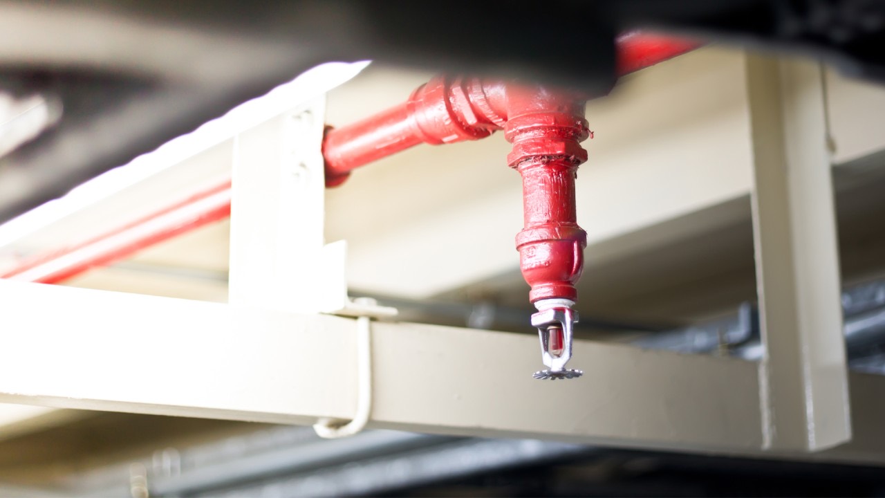 Fire sprinkler head on red pipe