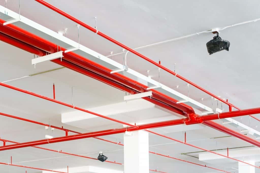 Red fire sprinkler piping in a commercial ceiling
